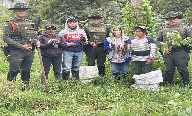 Policías de carabineros y comunidad en una siembra de árboles