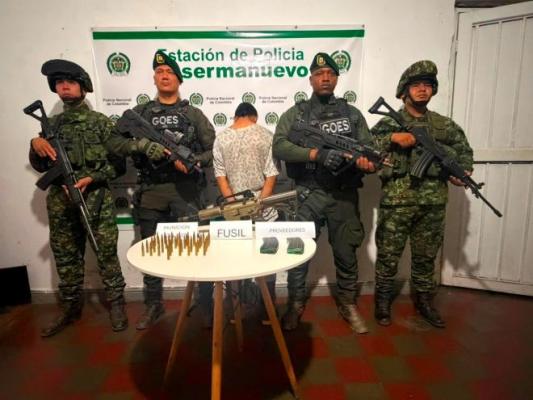 la policía el ejercito al lado de un hombre capturado con material incautado
