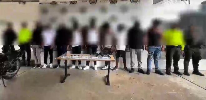 la polic&iacute;a nacional al lado de hombres capturados integrantes de grupo delincuencial