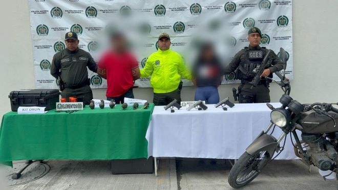 tres policías al lado de una pareja capturada con elementos incautados   