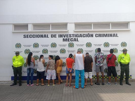 Personas capturadas-policías custodiando