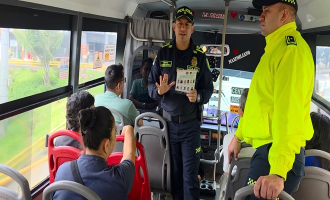 policías brinda información a ciudadanos dentro de un bus de transporte publico 