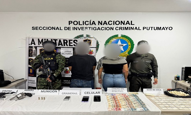 Polic&iacute;as, Ej&eacute;rcito presentan a dos personas capturadas y frente a ellos una mesa con los elementos probatorios incautados