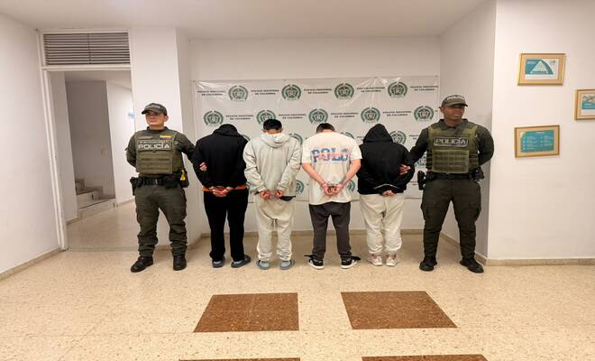 Cuatro personas capturadas las cuales se encuentran esposadas y dos policías en cada lado respectivamente 