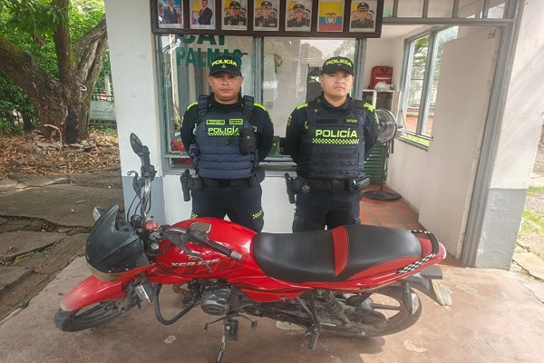 Dos policías con una de las motocicletas recuperadas