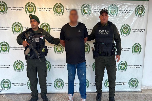 Dos policías custodian a un hombre capturado presunto cabecilla logístico
