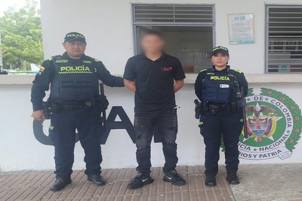 Dos polic&iacute;as custodian a un hombre capturado