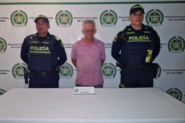 Dos Policías, un capturado, mesa con estupefacientes