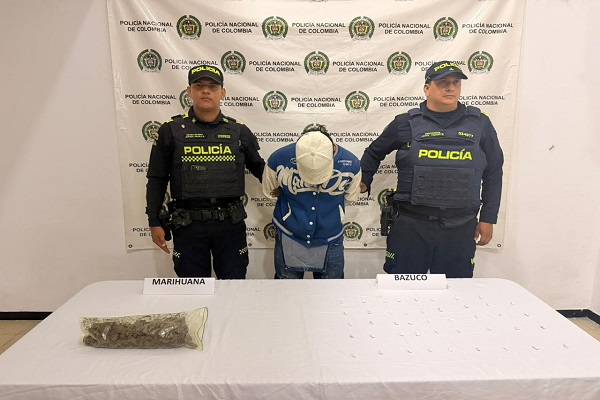 Dos Policías, un capturado y mesa con sustancias estupefacientes incautadas