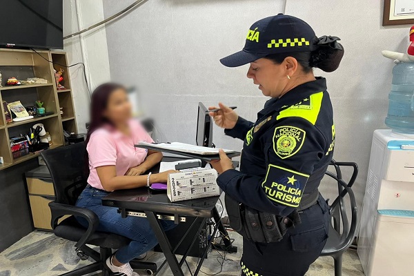 Policía de turismo y ciudadana en actividad en las agencia de viaje con el fin de fortalecer la seguridad