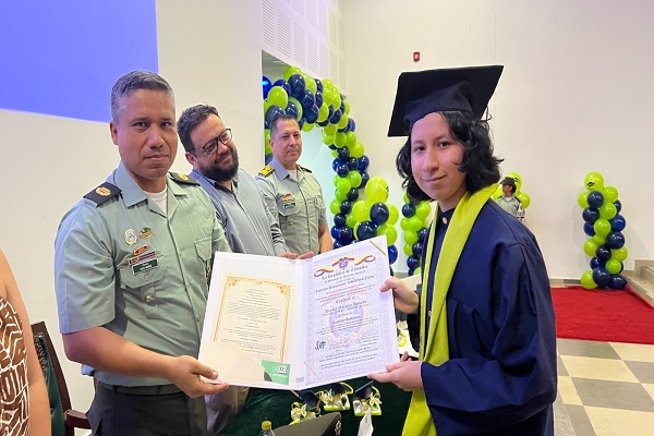 Policía entrega diploma a un estudiante durante la graduación