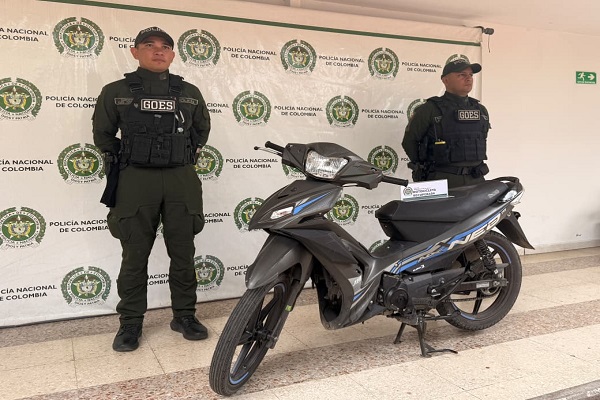 Dos policías presentan una motocicleta recuperada