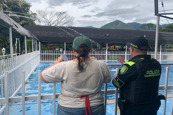Un funcionario de la Policía dialoga con un ciudadano frente a una psicina