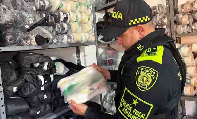 Funcionario de la policía fiscal y aduanera inspecciona los pares de calzado, presuntamente de contrabando y con vulneración de derechos de propiedad industrial
