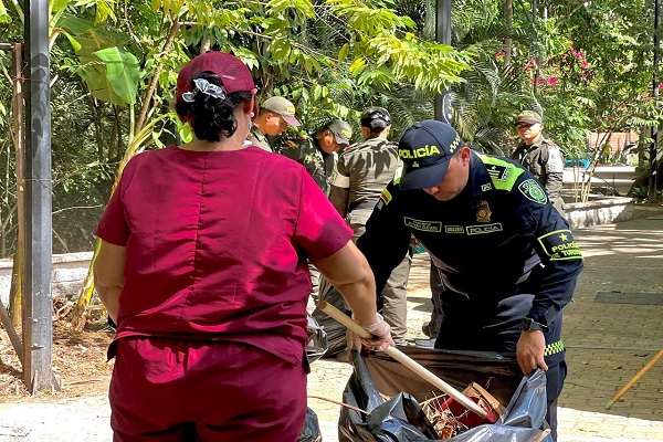 Policía y ciudadana realizan labores de limpieza en el Malecón