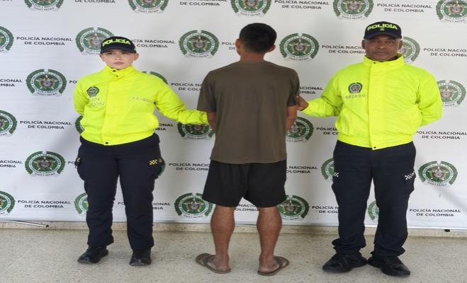 Dos uniformados y una persona capturada durante un procedimiento policial.