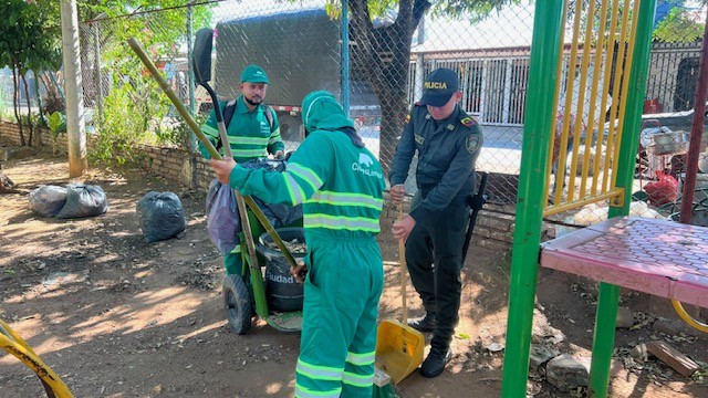 Un policía y dos funcionarios de Ciudad Limpia realizan la recolección de residuos