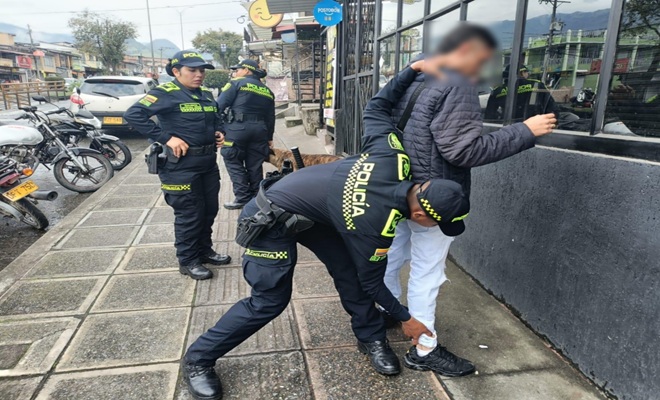 dos polic&iacute;as practicando el registro personal a un ciudadano 