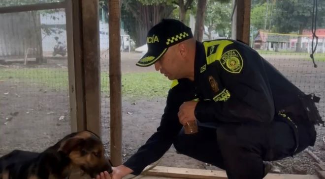 un polic&iacute;a al lado de un perro